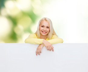 Wall Mural - smiling woman in sweater with blank white board