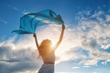 Fototapeta Góry - Beautiful young woman holding blue scarf on the wind