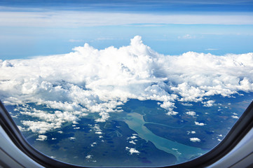 Canvas Print - Aerial view of land and rivers with clouds from airplane window