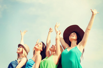 Canvas Print - smiling girls with hands up on the beach