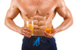 Muscular healthy man holding a juice and orange