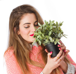 Wall Mural - Young girl smelling a plant