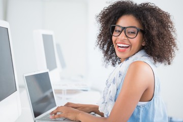 Wall Mural - Pretty hipster working at her desk on laptop