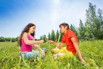 Wall Mural - Children play rock-paper-scissors on grass