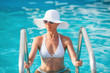 © milanmarkovic78 - Beautiful woman out of the pool on ladder