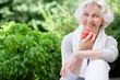 Leinwandbild Motiv Sportliche Seniorin mit Apfel