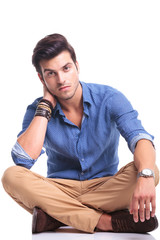 Poster - serious young man sitting on white background