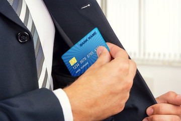 Close up of a businessman getting credit card from his pocket.