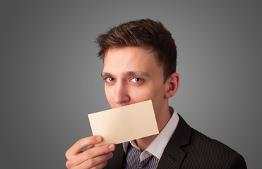 Businessman holding white card at front of her lips with copy sp