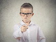 Angry bossy boy pointing finger at someone, grey background 