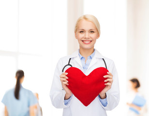 Canvas Print - smiling female doctor with heart and stethoscope