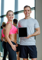 Sticker - smiling young woman with personal trainer in gym