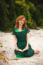 Redhead Woman In Green Dress Reading Book At Garden