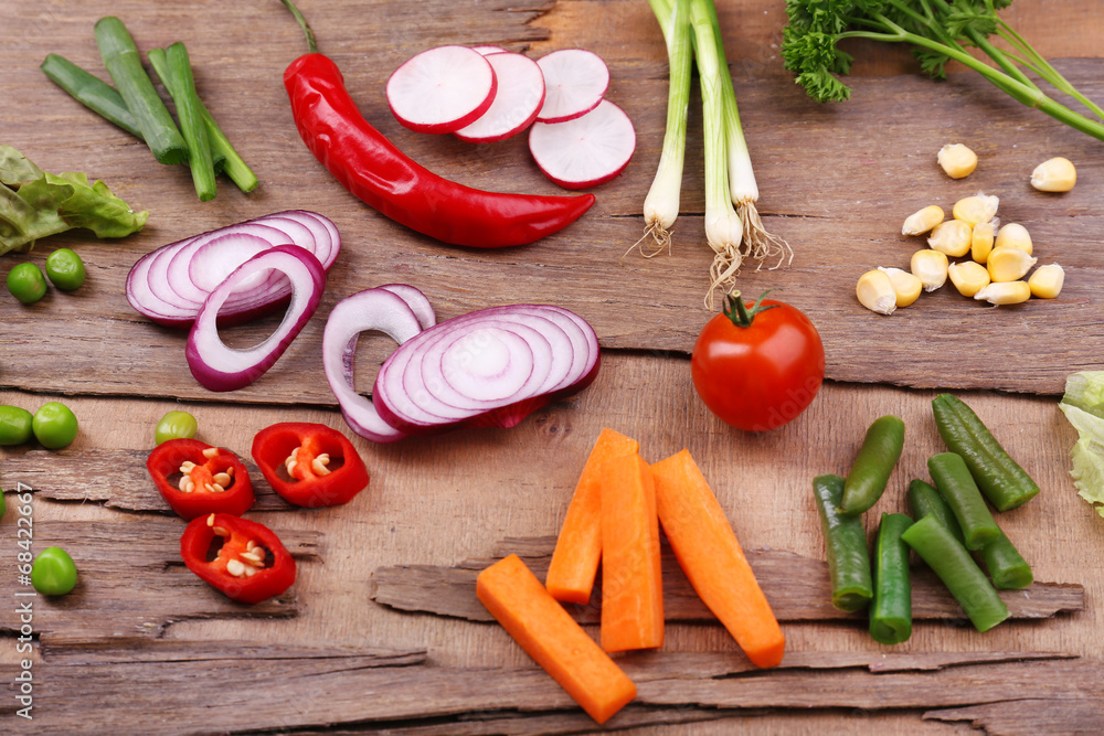 Different kind of raw vegetables on wooden table