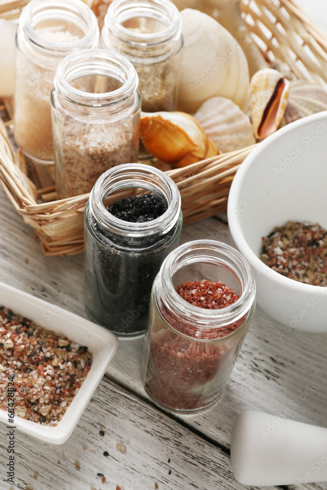 Different sea salt on wooden table, close up
