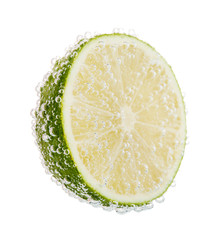 Wall Mural - Fresh lime in water with bubbles, isolated on white