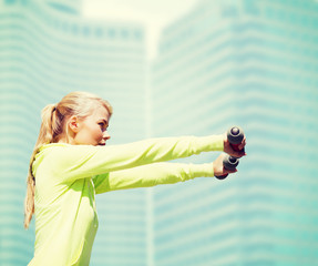 Wall Mural - sporty woman with light dumbbells outdoors