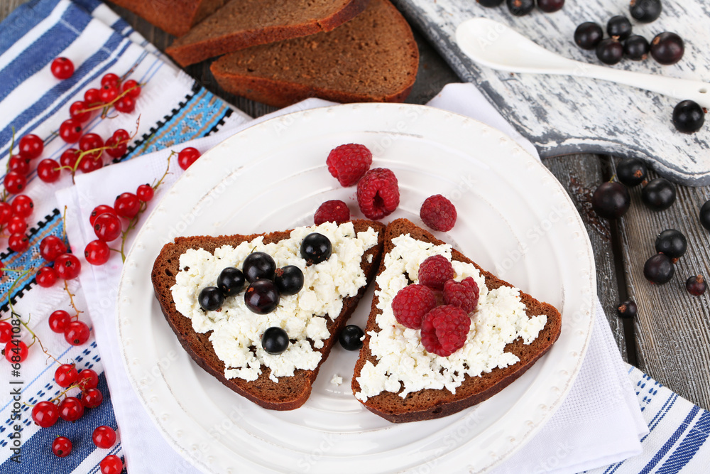 Bread with cottage cheese and berries on plate close-up