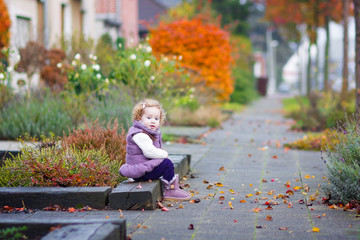 Wall Mural - Little girl in a autumn city street