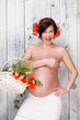 Naked pregnant woman with flowers