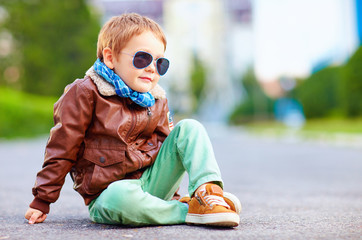 cute stylish boy in leather jacket sitting on the road