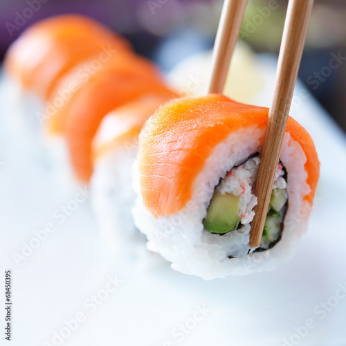 Tapeta ścienna Podnosząc kawałek sushi z pałeczkami