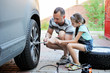 © Alinute - Cute  girl helps her father to change wheel