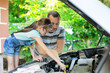 © Alinute - Father teaching his daughter to change motor oil in the car
