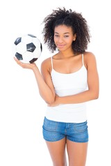 Wall Mural - Pretty girl holding football and smiling at camera