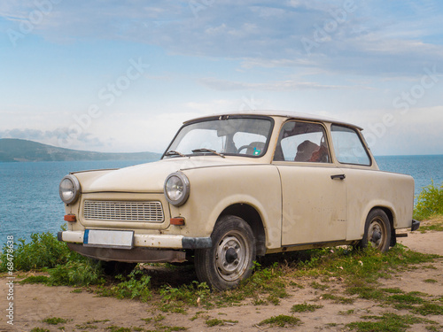 bialy-trabant-na-plazy-na-tle-niebieskiego-morza