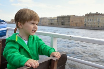 baby boy on boat looking on water