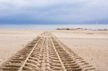 Tyre Tracks On The Sand Of The Beach
