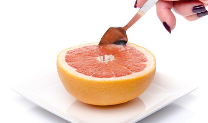 Poster - Woman's hand taking a piece of fresh grapefruit with a spoon