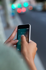 mobile phone in a woman's hand in the city at night.