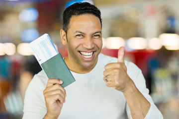 Wall Mural - mid age man holding boarding pass and giving thumb up