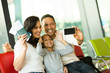© michaeljung - family taking self portrait with smart phone at airport