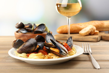 Wall Mural - Tasty noodles with mussels on table, close up