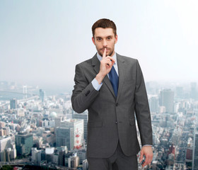 Poster - young businessman making hush sign