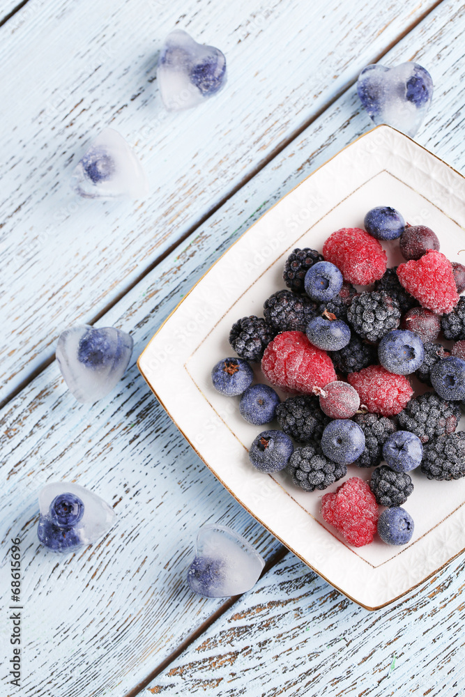 Frozen berries on color wooden background