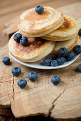 Wall Mural - Homemade fritters with fresh blueberries over wooden background