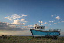 Abandoned Fishing Boat On Beach Landscape At Sunset