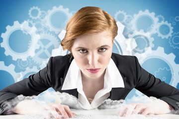 Poster - Composite image of redhead businesswoman sitting at desk typing