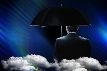 Poster - Composite image of mature businessman holding an umbrella