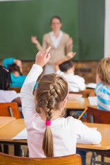 Wall Mural - Pretty teacher talking to the young pupils in classroom