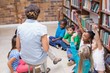 © WavebreakmediaMicro - Cute pupils and teacher having class in library