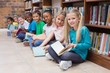© WavebreakmediaMicro - Cute pupils sitting on floor in library