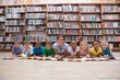 © WavebreakmediaMicro - Cute pupils and teacher lying on floor in library