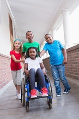 Wall Mural - Cute disabled pupil smiling at camera in hall with her friends