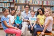 © WavebreakMediaMicro - Cute pupils and teacher reading in library