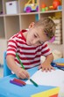 © WavebreakMediaMicro - Cute little boy drawing at desk